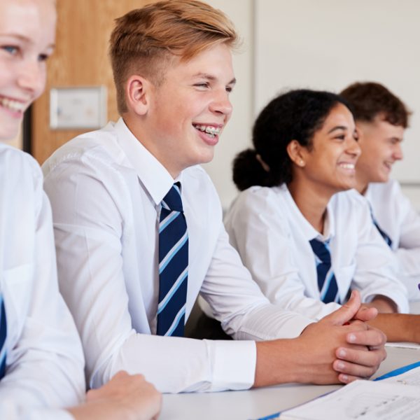 Line,Of,High,School,Students,Wearing,Uniform,Sitting,At,Desk